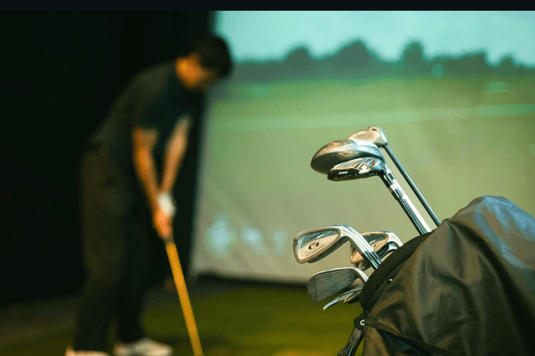 A set of clubs beside the simulator screen